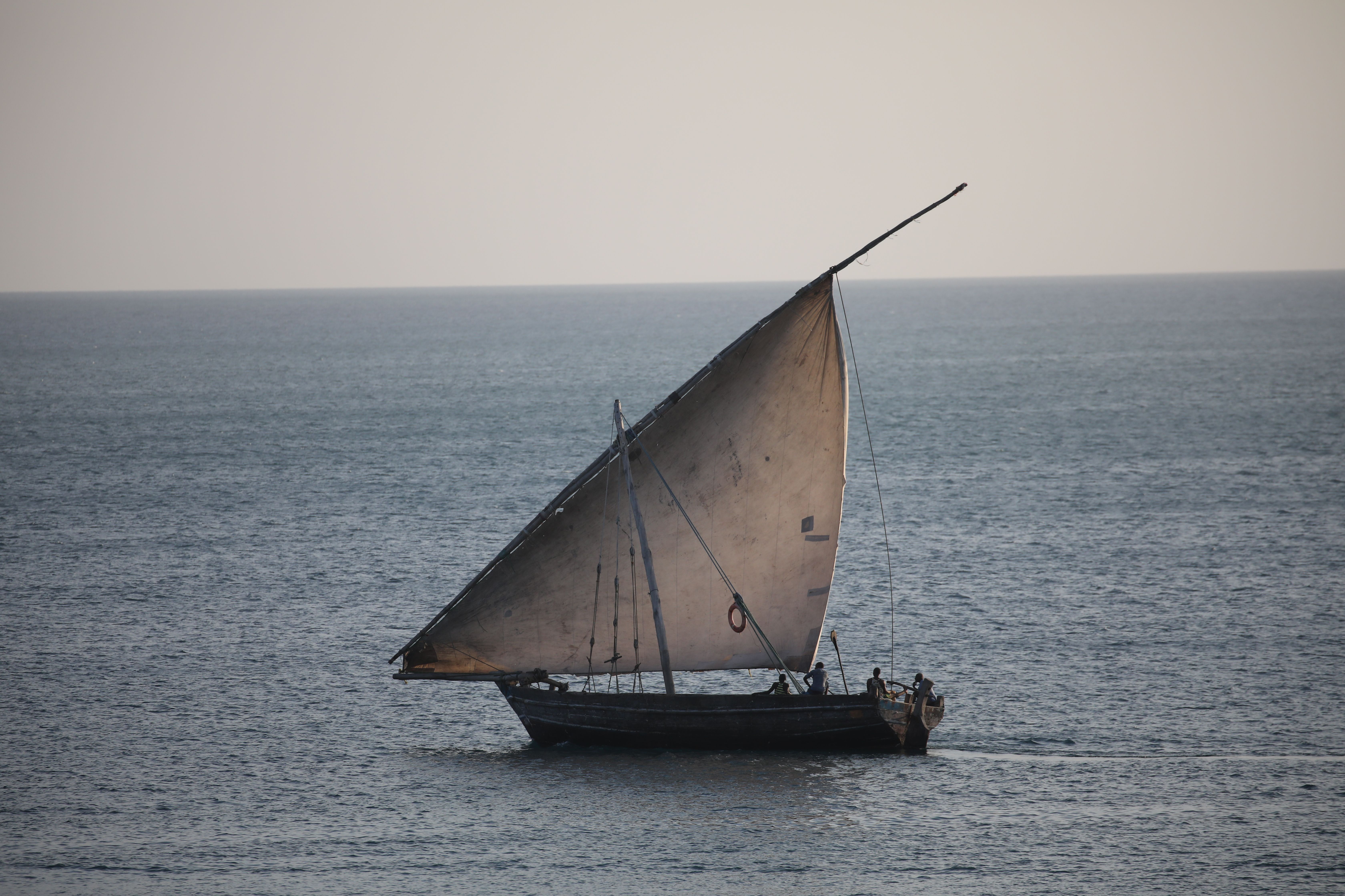 Voilier traditionnel en bois sous voile latine, en mer au crépuscule