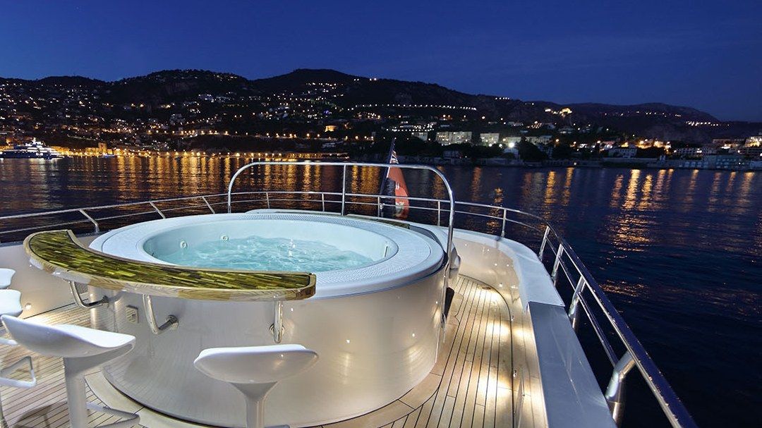 Jacuzzi de pont du Galaxy de nuit, rade éclairée en arrière-plan